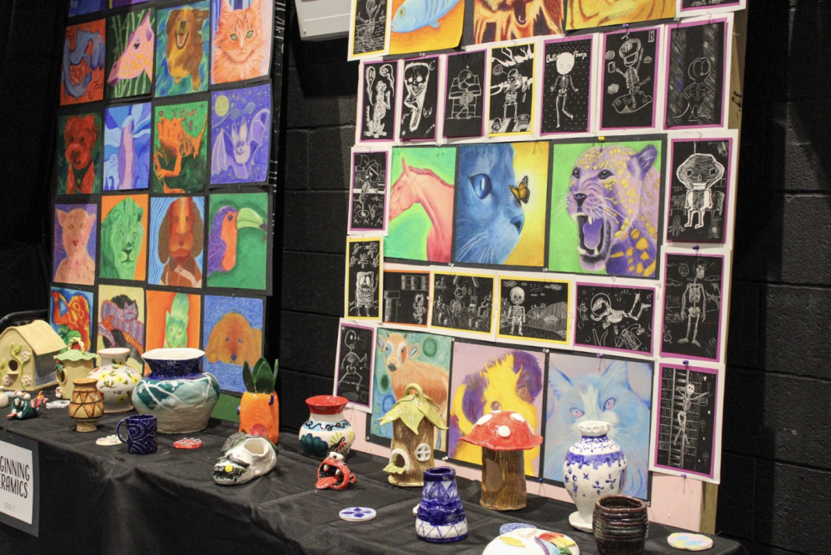 Beginning ceramics art pieces are displayed throughout the black box for students to walk around and look at.